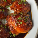 Tender honey garlic slow cooker chicken thighs with carrots, onions, and fresh herbs - a delicious, hands-off dinner.
