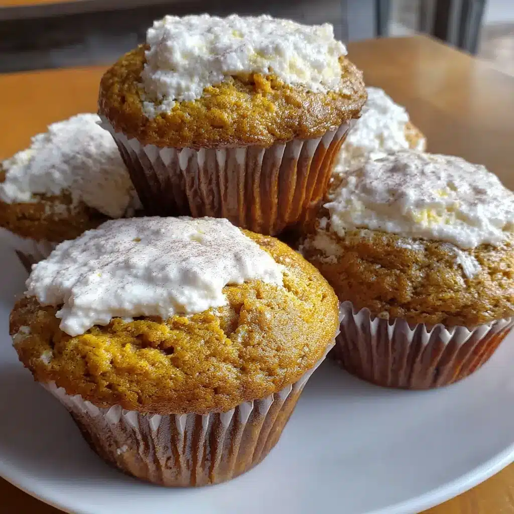 Close-up view of a freshly baked, moist pumpkin cream cheese muffin showcasing its delightful texture and cream cheese swirl, perfect for a fall treat recipe.