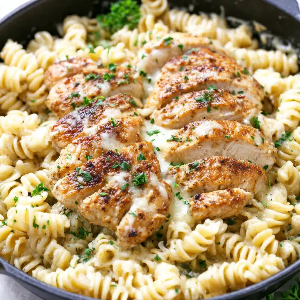 Easy healthy garlic parmesan chicken pasta is shown in a close-up image that highlights the creamy sauce and perfectly cooked chicken.