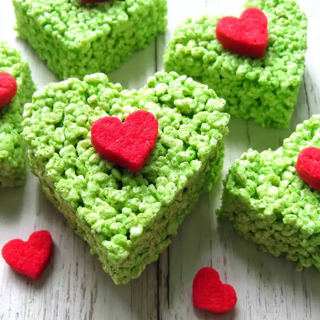 Close-up of festive Grinch Heart Rice Krispies Treats, perfect for a Christmas party.