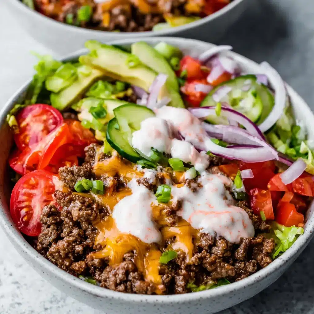 Low Carb Burger Bowl with Sauce Close-up of delicious Low Carb Loaded Burger Bowls with Sauce, showcasing the layers of ground beef, toppings, and creamy sauce.