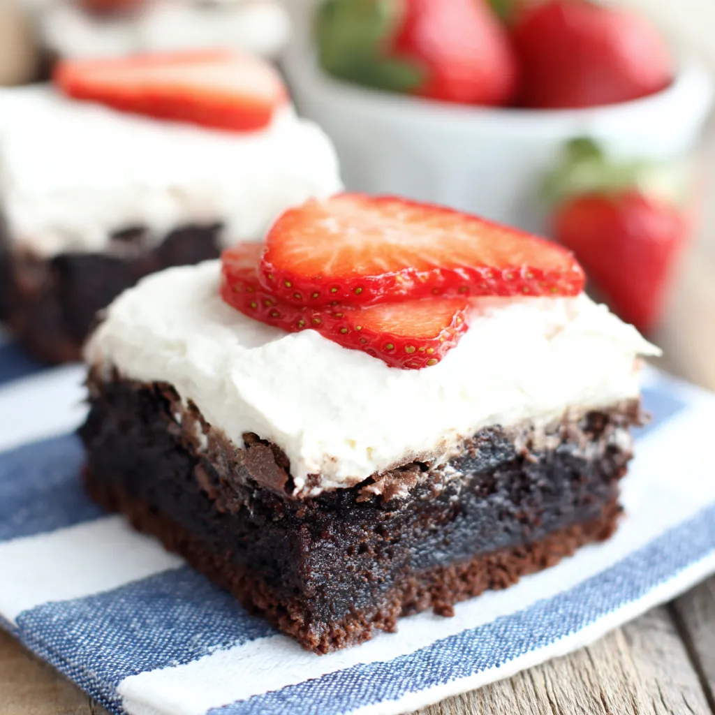 A decadent serving of Strawberry Shortcake Brownies topped with fresh sliced strawberries and homemade whipped cream.